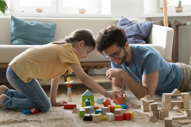istock Positive engaged young dad and daughter kid playing with cubes 1475969986