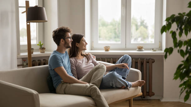 istock Happy dreamy young couple hugging on sofa 1475970037