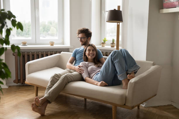 istock Cheerful young married couple resting on home couch 1475970038