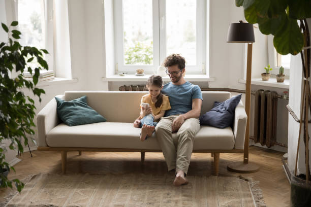 istock Positive young father and little daughter kid using mobile phone 1475970076