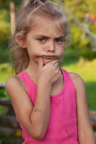 istock Curious little girl touching chin 1475970429