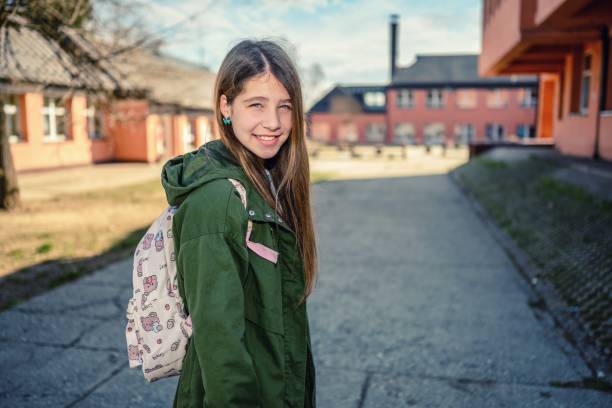 Portrait of a happy Latin American girl walking to school in her uniform and smiling - education concepts