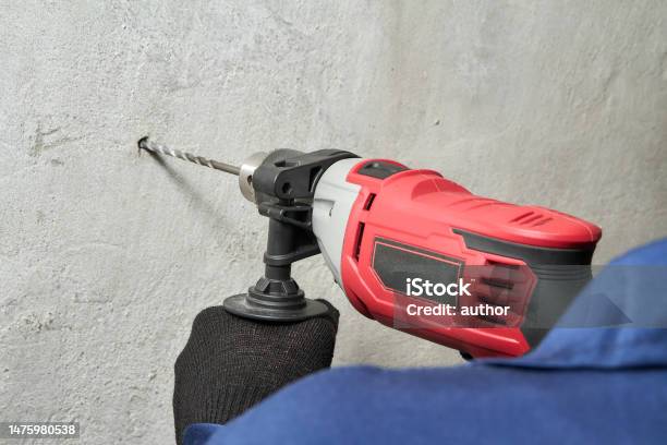 Drilling A Hole In The Wall With A Drill Stock Photo - Download