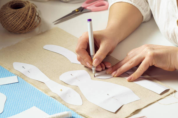 istock Sewing patterns for future toy or clothes. Cropped designer, seamstress pin, make paper sewing patterns, paint contour 1475983019