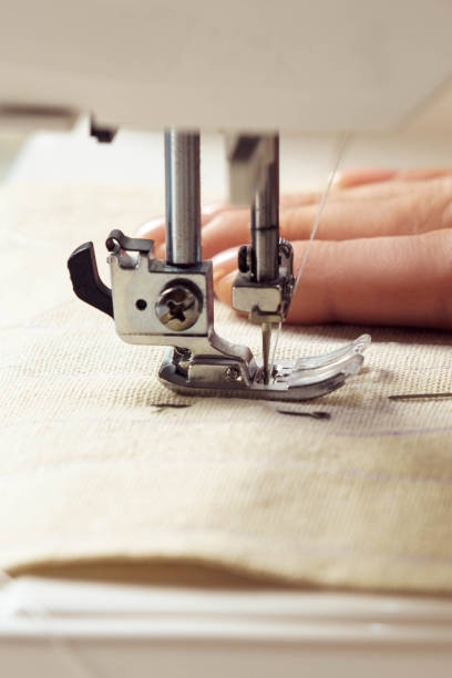 vertical close up cropped woman hand use sewing machine for repair clothes with thread stitching. tailor seamstress work - sewing foot imagens e fotografias de stock