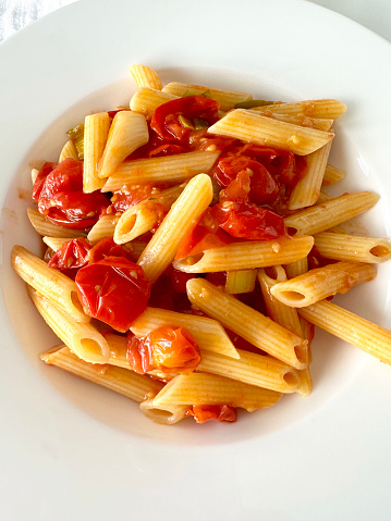 close-up of penne pasta with fresh cherry tomatoes