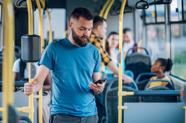Man using smartpone while riding in a bus stock photo