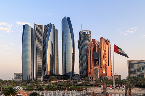 Abu Dhabi, UAE - February 27. 2023: Etihad Towers with UAE flag. Etihad Towers are a group of five buildings for offices, apartments and the hotel Grand Hyatt