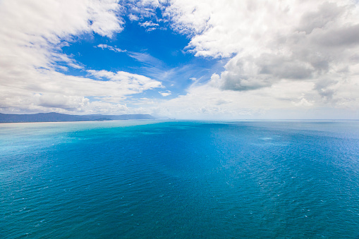 Aerial view of bright blue ocean meeting the Great Barrier Reef, Queensland, Australia.