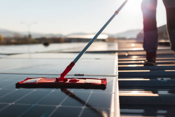 istock Close-up of a young man cleaning solar panels on a rooftop 1475996461
