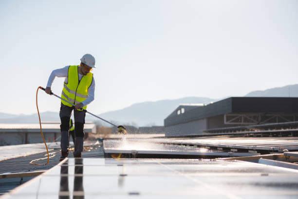 istock Young worker cleaning solar panels on a sunny day 1475997157