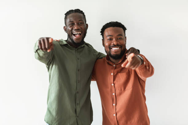 istock Two Happy African Guys Pointing Fingers At Camera, White Background 1476000674