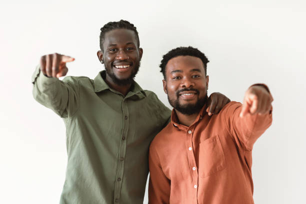 istock Two Cheerful Black Males Pointing Fingers Standing Over White Background 1476000695