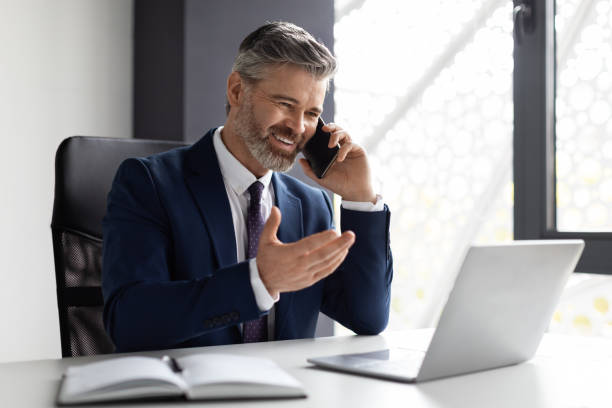 istock Corporate Communication. Handsome Middle Eaged Businessman Talking On Cellphone In Office 1476001616