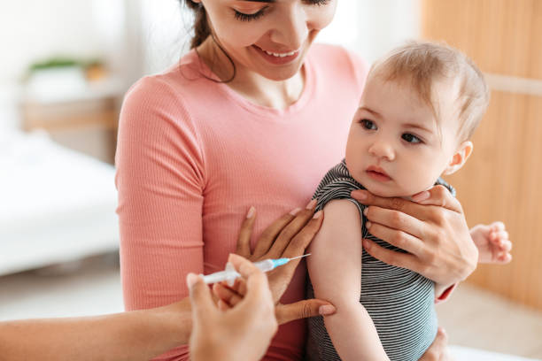 Vaccination concept. Pediatrician doctor giving vaccine shot to little baby at home, making injection for infant child Vaccination concept. Pediatrician doctor giving vaccine shot to little baby at home, making injection for infant child, afraid kid looking at doc 3 6 months stock pictures, royalty-free photos & images