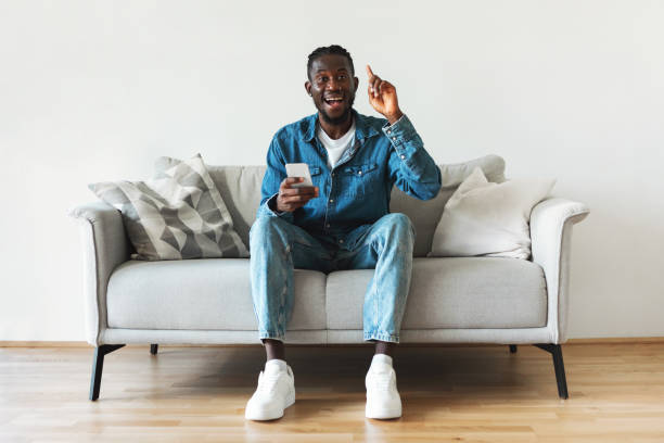 istock Excited African American Guy Holding Smartphone Having Idea Sitting Indoors 1476002344