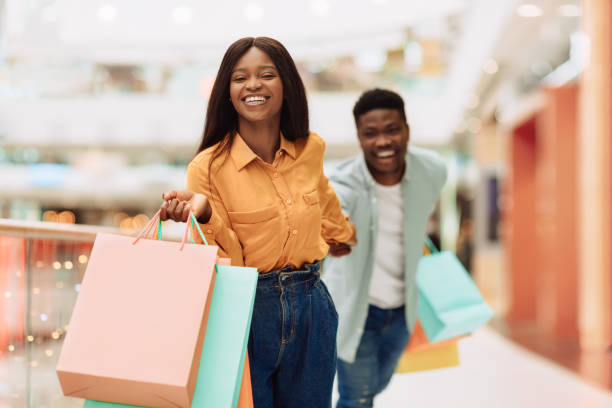 istock Excited Black Woman Pulling Boyfriend To Shopping Store 1476002620