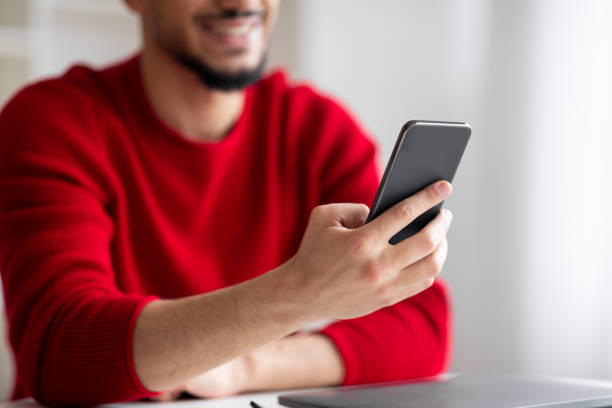 istock Cropped smiling young islamic man with beard typing on smartphone in home office interior 1476002765