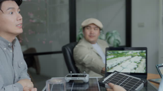 Asian businessman raising a question while in a meeting about the new solar panel model.