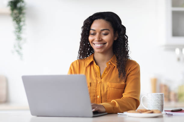 istock Happy african american woman working from home, using laptop 1476003845