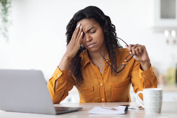 istock Exhausted black woman having headache while working from home 1476004136