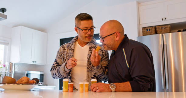 istock Mixed Race Gay Couple Examining Pill Bottles Inside the Kitchen 1476004339