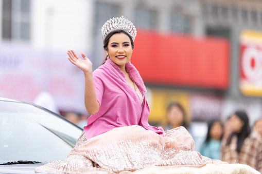 Valle Hermoso, Tamaulipas, Mexico - March 18, 2023: City Anniversary Parade, Beauty queen wearing her crown and a traditional dress, riding a vehicle during the parade