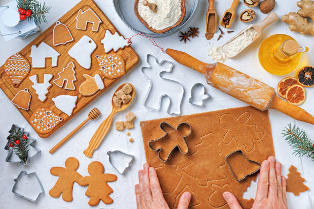 istock Christmas gingerbread different shaped with ingredients for gingerbread and the hands of a woman baker, top view, flat lay 1476007346
