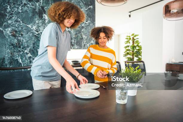 Mixed Race Girls Setting The Table For A Family Dinner Stock Photo - Download Image Now