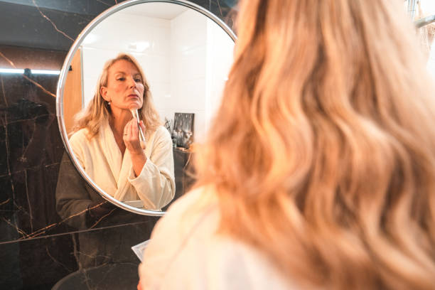 istock Mature Female In A Modern Bathroom Doing Her Makeup 1476011680