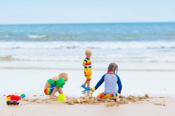 istock Kids on tropical beach. Children playing at sea. 1476016663