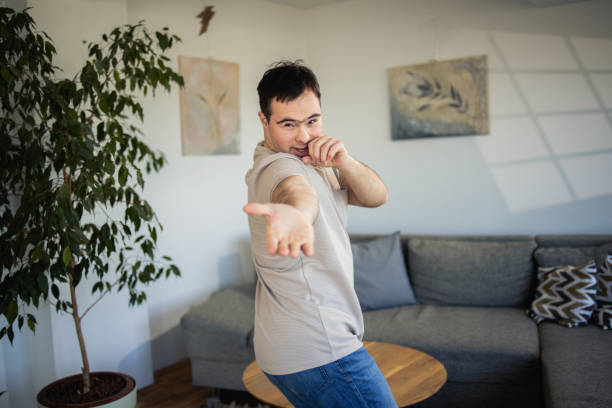 istock Happy man with Down syndrome enjoying at home 1476018449