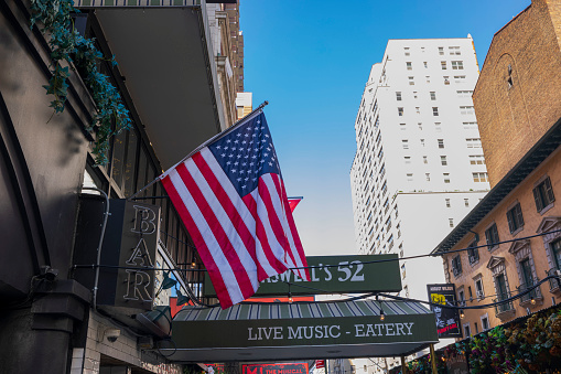 NY. USA. 09.20.2022. Close-up view of American flag on theater building at Neil Simon Theatre, Manhattan.