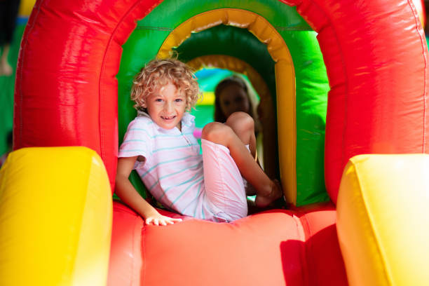 istock Child jumping on playground trampoline. Kids jump. 1476022234