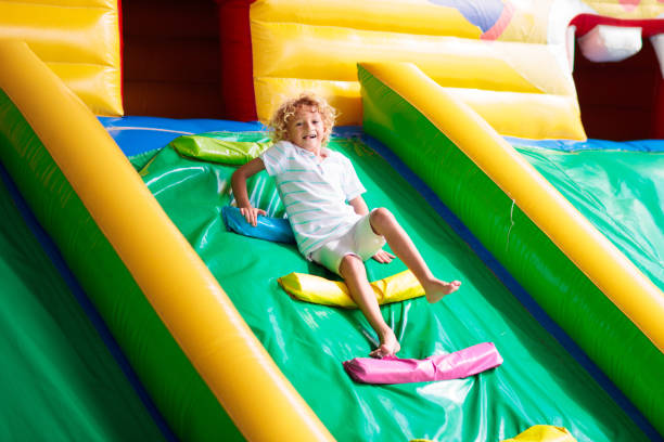 istock Child jumping on playground trampoline. Kids jump. 1476022389