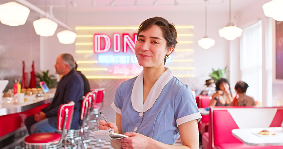 Foto POV de la camarera sonriendo tomando el orden en el restaurante de estilo de la década de 1950 photo