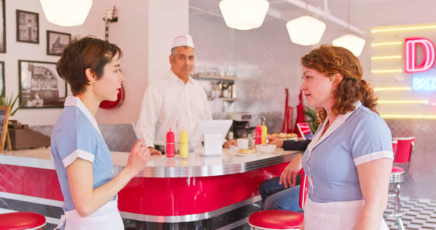 istock Waitresses Talking To Each Other In 1950s Styled Diner 1476022809