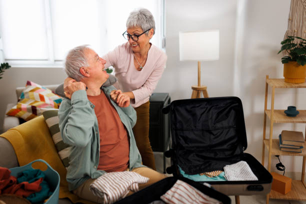 istock Senior couple having affectionate moment while packing for a trip in their apartment 1476022812
