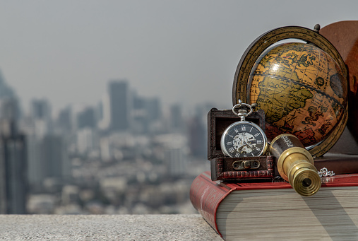Travel or adventure concept background. Pocket watch, binoculars, book, globe with a sky background. Journey Concept, Copy Space, Vintage Style.