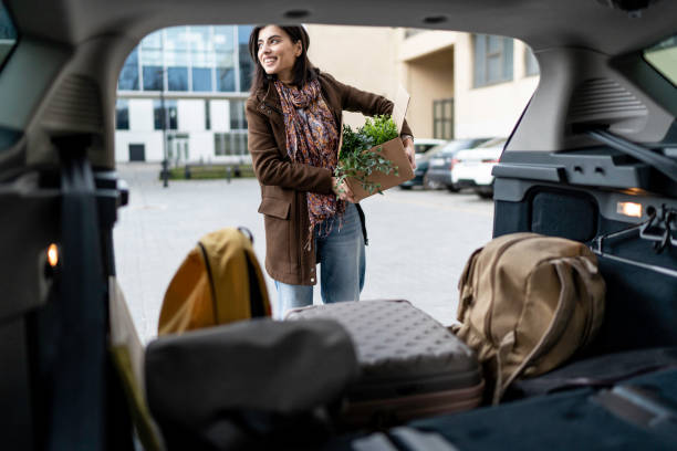 istock young beautiful woman packing a box into the car trunk 1476025523