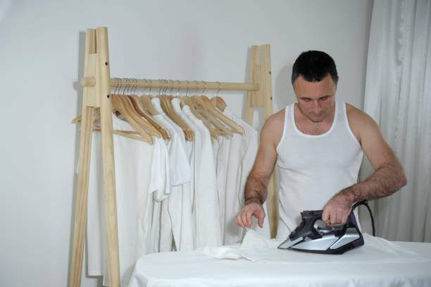 istock bachelor single man adult handsome man ironing shirt going to work independence adulthood strength background white clothes in underwear wooden hanger ironing board iron white curtains home comfort 1476025527