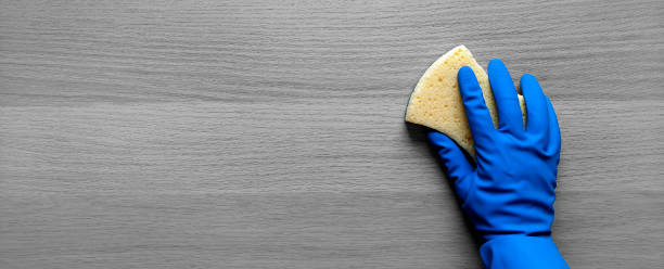 istock Banner with cleaner's hand and kitchen sponge. Flat lay. Tackling the Mess. Place for text. 1476026629
