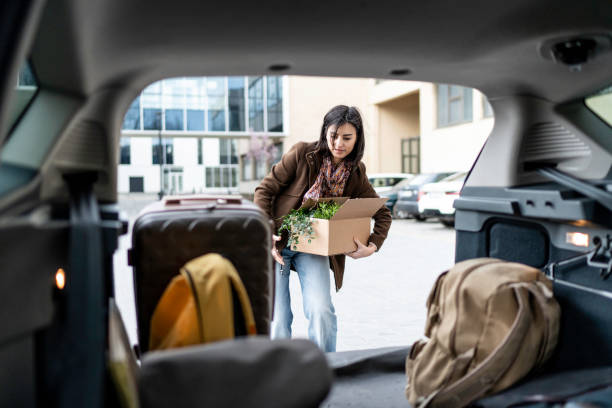 istock young beautiful woman packing a box into the car trunk 1476026720