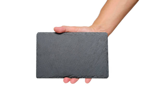 istock Grey stone slate cutting board with an empty space for text, in hand, on white background. 1476041760