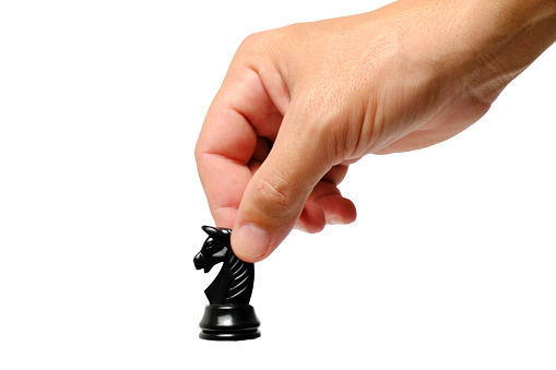 Black chess piece in hand on a white background