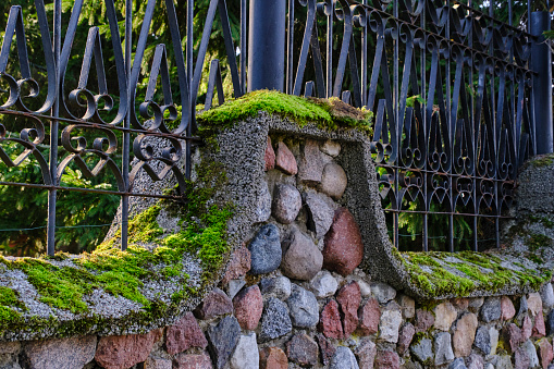 Old stone fence overgrown with green moss