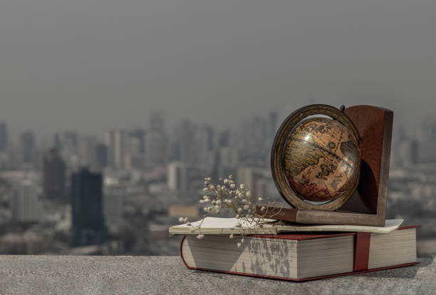 Journey and Learning concept background. Globe and stack of books with a sky background. Copy space.