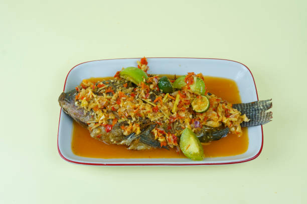 Pecak Ikan Mujair or Tialipa fish is a traditional Indonesian dish that originated from Betawi, Indonesia. stock photo