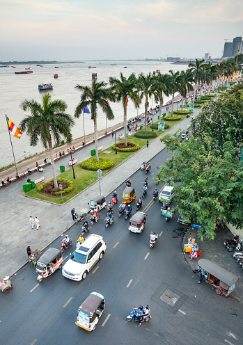 Phnom Penh,Cambodia-December 23rd 2022:Alongside the Tonle Sap River,crowds of Khmer people and families gather at sunset,in the relative cool of the day,to socialize,eat,pray and exercise.