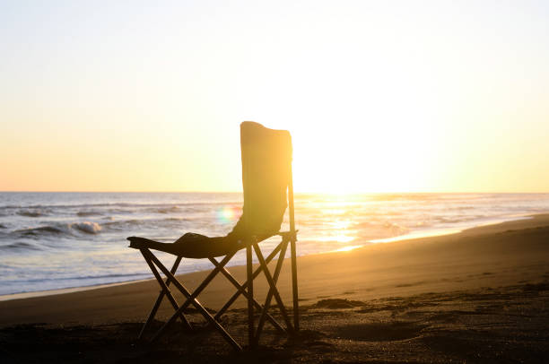istock a chair on the beach at sunset 1476080290